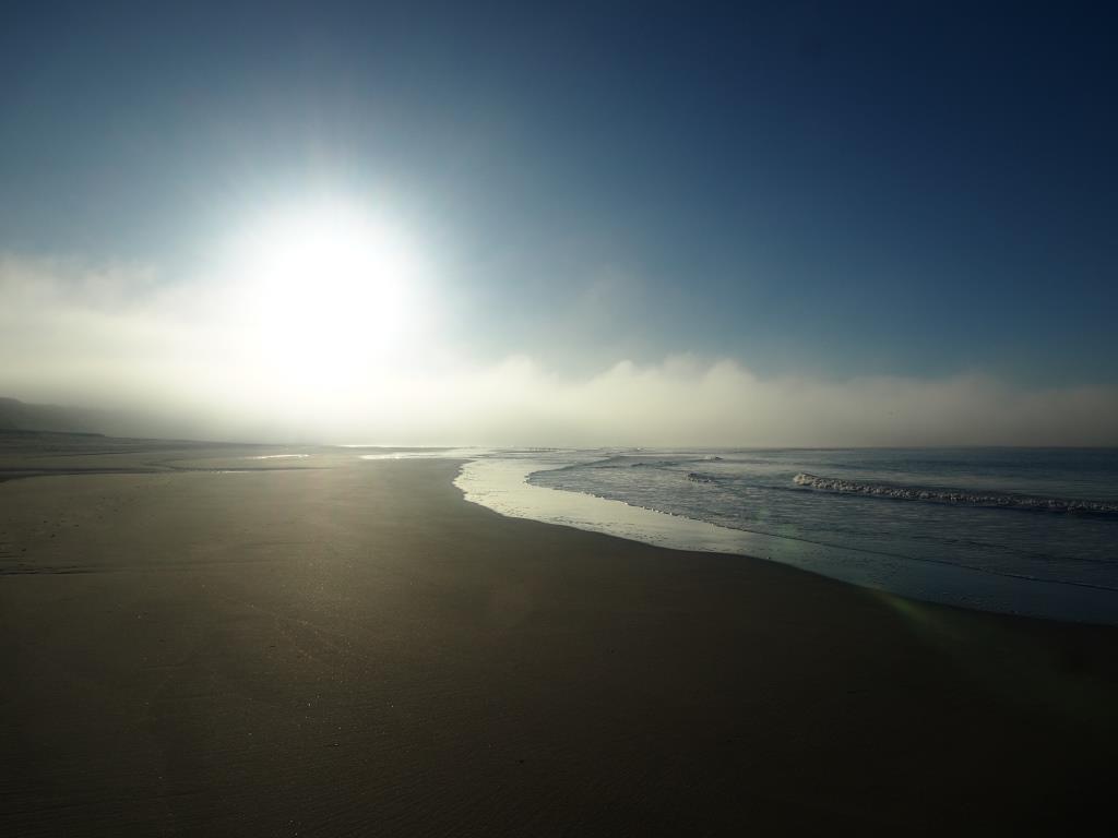 weiter Sandstrand mit Blick auf die Sonne